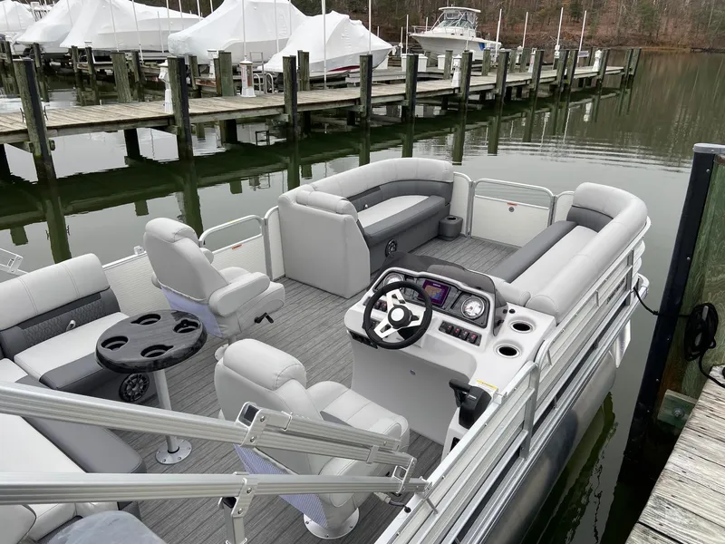 Slide: The Image of 2020 Sweetwater 2286 SFL pontoon boat docked, featuring spacious seating and modern controls. - 12
