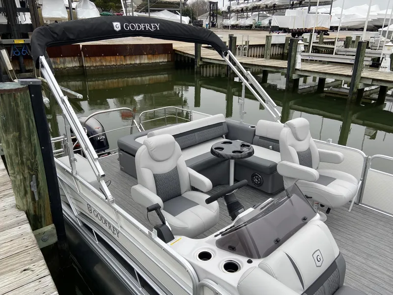 Slide: The Image of 2020 Sweetwater 2286 SFL pontoon boat docked, featuring comfortable seating and sleek design. - 13