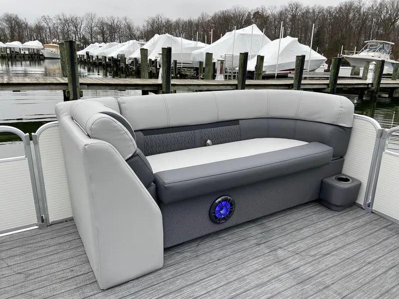 Slide: The Image of 2020 Sweetwater 2286 SFL pontoon boat with gray seating and blue speaker at marina. - 15