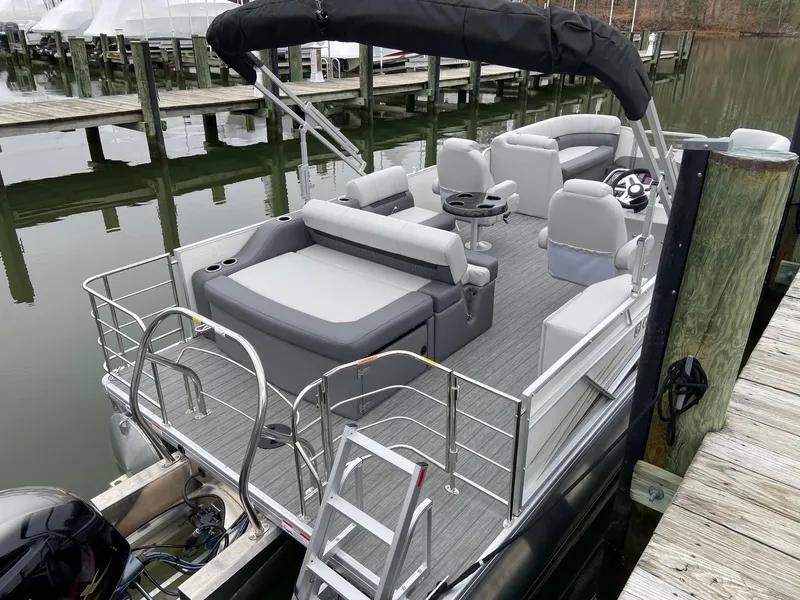 Slide: The Image of 2020 Sweetwater 2286 SFL pontoon boat docked, featuring spacious seating and modern design. - 9