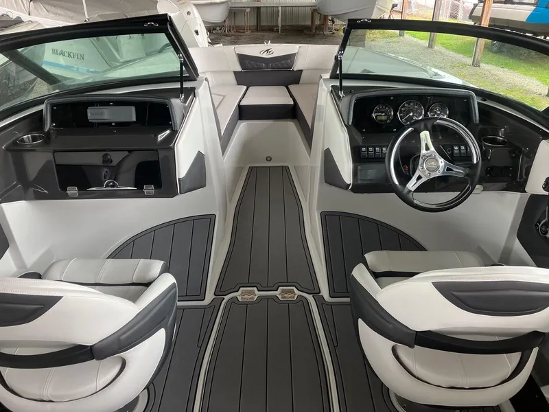 Slide: The Image of 2023 Monterey M-225 boat interior with dual captain seats and modern dashboard. - 2