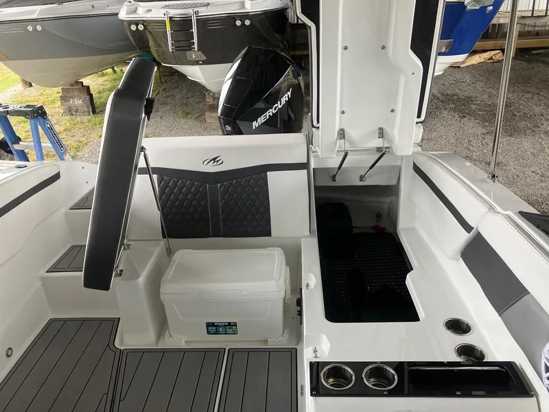 Slide: The Image of 2023 Monterey M-225 boat interior with seating, storage, and Mercury outboard motor. - 4