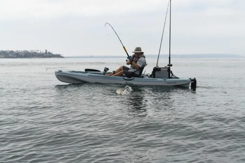 The Image of Man fishing from a 2022 Hobie Mirage Passport 12.0 kayak on calm waters. - 0