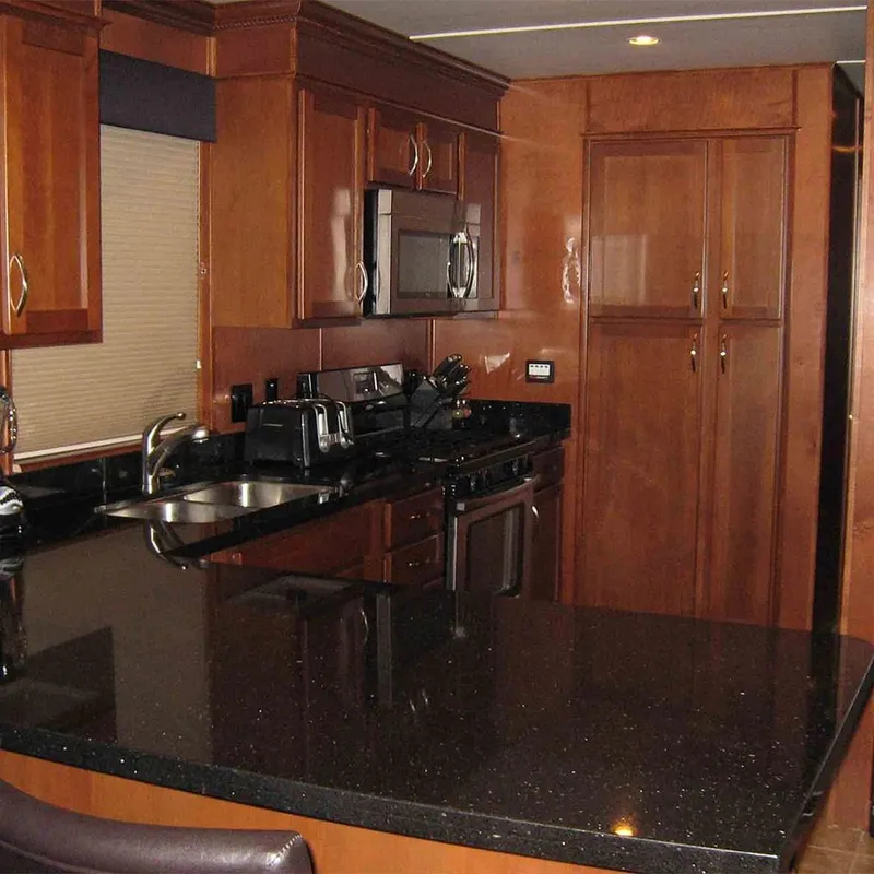 Slide: The Image of Modern kitchen in 2010 Bravada Dream Catcher Trip 14 RV with black countertops. - 2