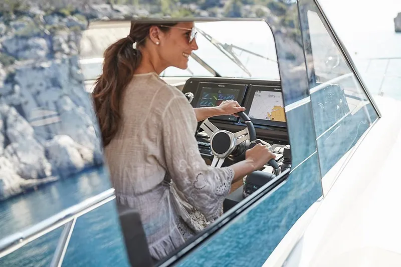 Slide: The Image of Woman piloting 2023 Prestige 460 S yacht on a sunny day. - 13