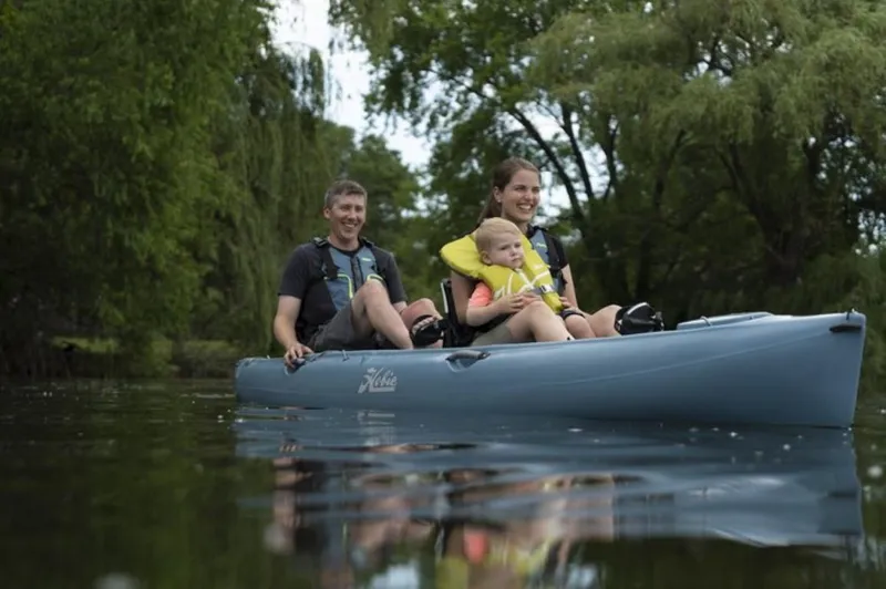 The Image of Family kayaking on a 2023 Hobie Mirage Oasis in a serene lake. - 0