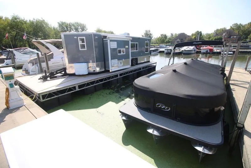 Slide: The Image of 2020 Harbor Home 24' houseboat docked at a marina with other boats. - 16