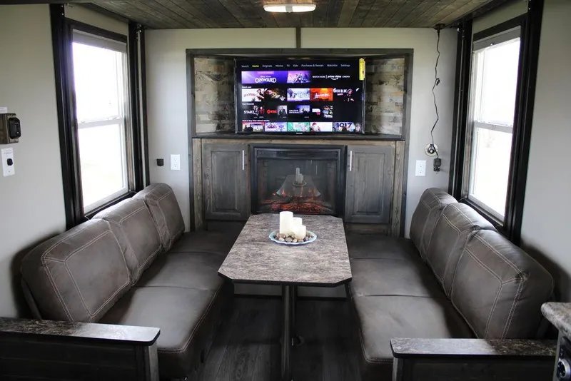 Slide: The Image of 2020 Harbor Home 24' interior with cozy seating, TV, and fireplace. - 18