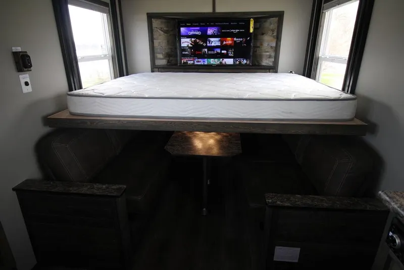 Slide: The Image of 2020 Harbor Home 24' interior with bed, dining area, and TV. - 19