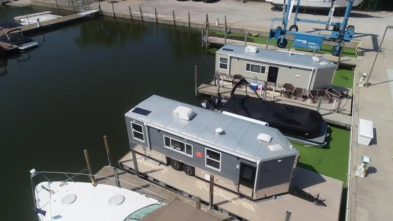 Slide: The Image of Harbor Home 24' 2020 model houseboats docked at a marina. - 2