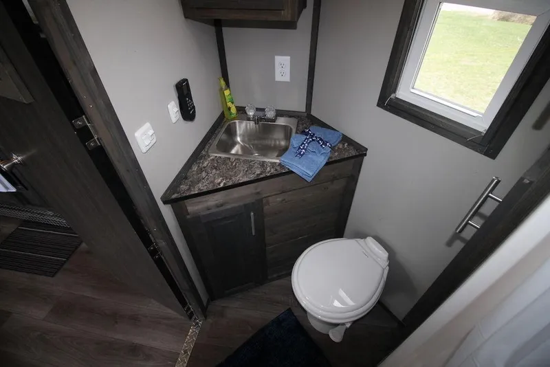 Slide: The Image of Compact bathroom in 2020 Harbor Home 24' model with sink, toilet, and window. - 26