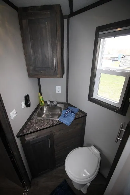 Slide: The Image of Compact bathroom in 2020 Harbor Home 24' model with sink, toilet, and storage. - 29
