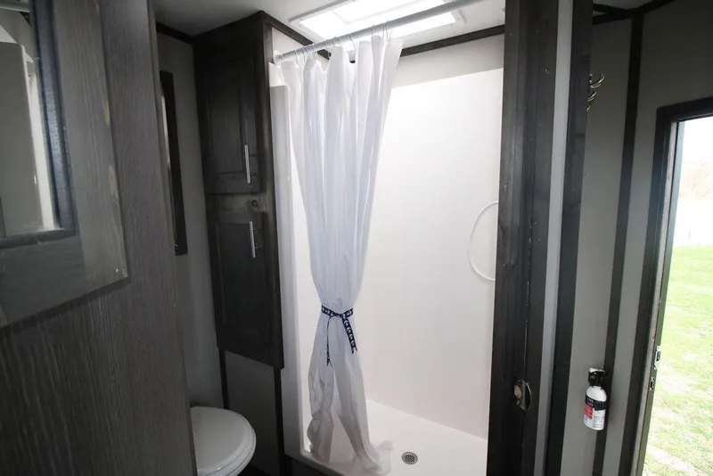 Slide: The Image of Modern bathroom in 2020 Harbor Home 24' model with shower and dark wood cabinets. - 30