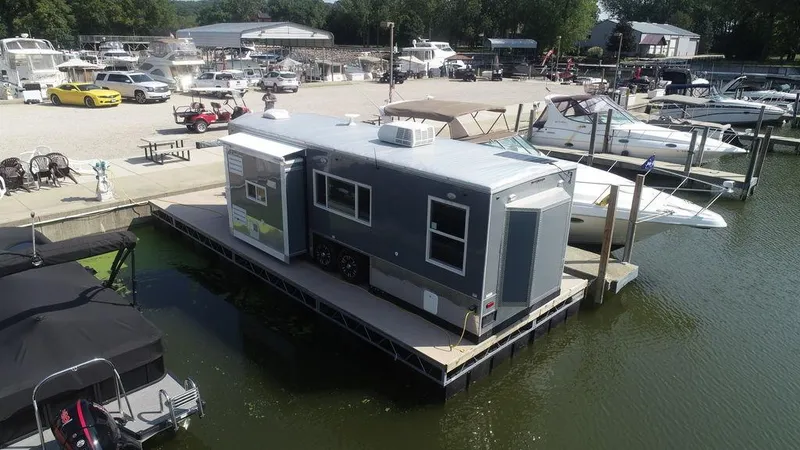 Slide: The Image of 2020 Harbor Home 24' floating house docked at a marina with boats. - 6