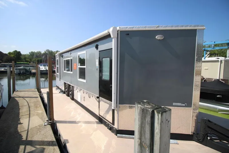 Slide: The Image of 2020 Harbor Home 24' houseboat docked at a marina on a sunny day. - 9