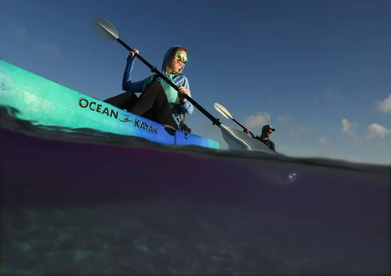 Slide: The Image of Two people kayaking on an Ocean Kayak Malibu 9.5, 2023 model, in clear waters. - 10