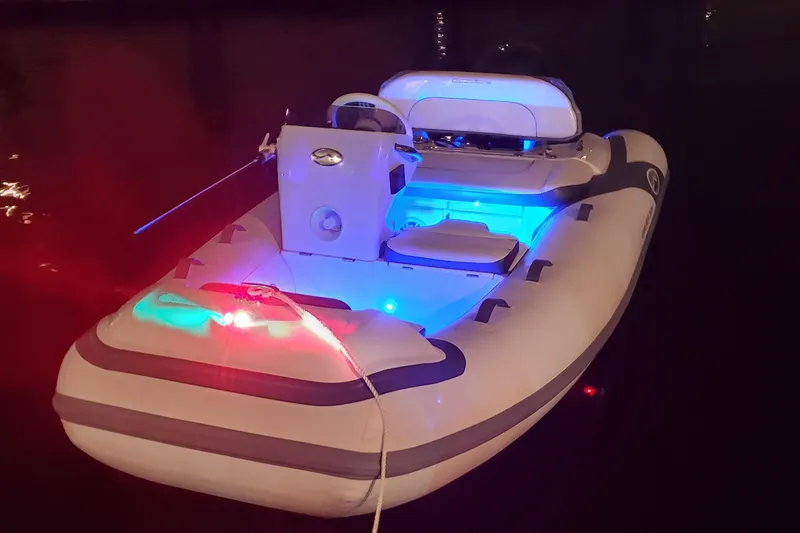 Slide: The Image of Walker Bay Generation 11 LTE 2025 inflatable boat with LED lights at night. - 1