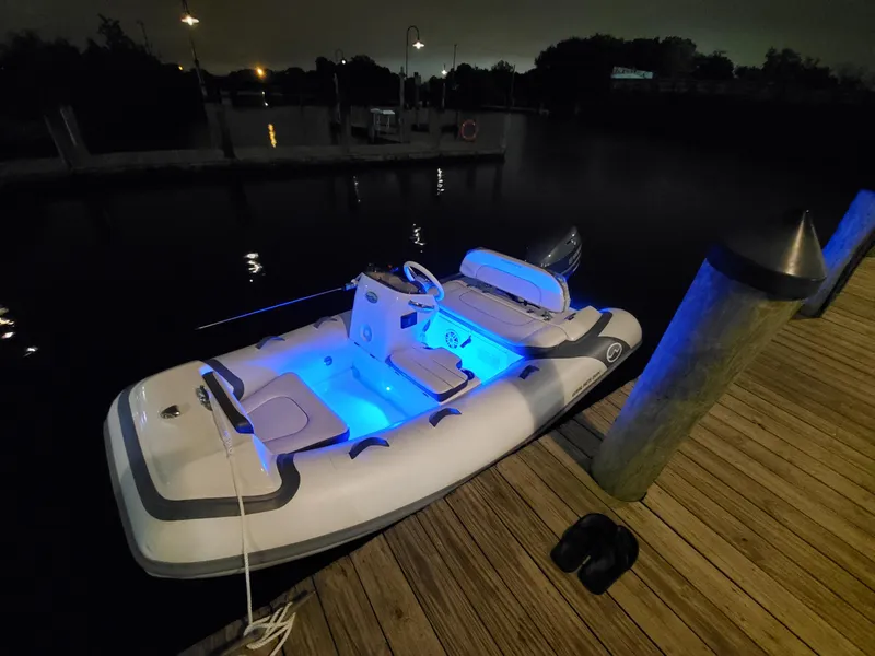 Slide: The Image of Walker Bay Generation 11 LTE 2025 boat docked at night with blue interior lights. - 2