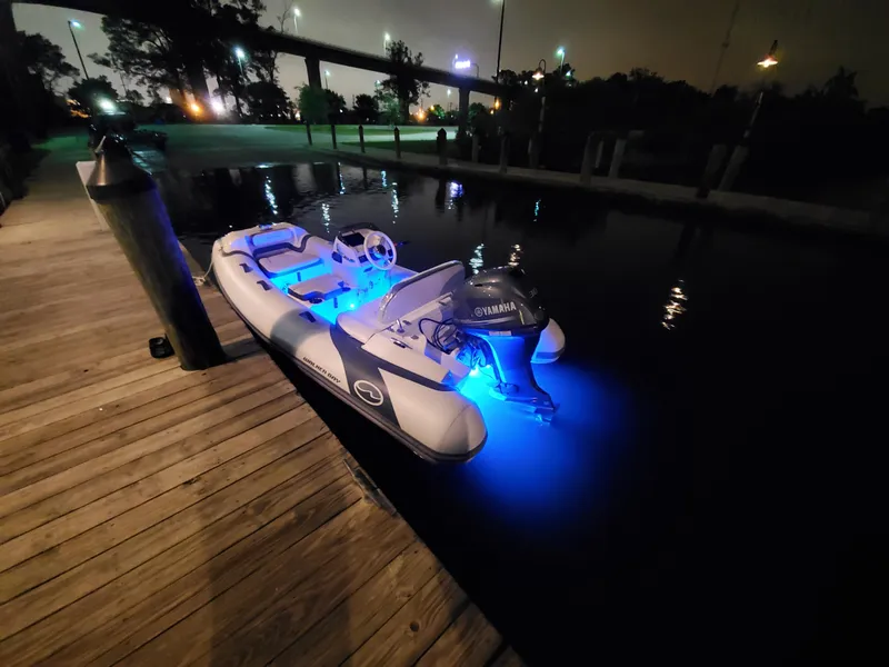 Slide: The Image of Walker Bay Generation 11 LTE 2025 boat with blue LED lights docked at night. - 3