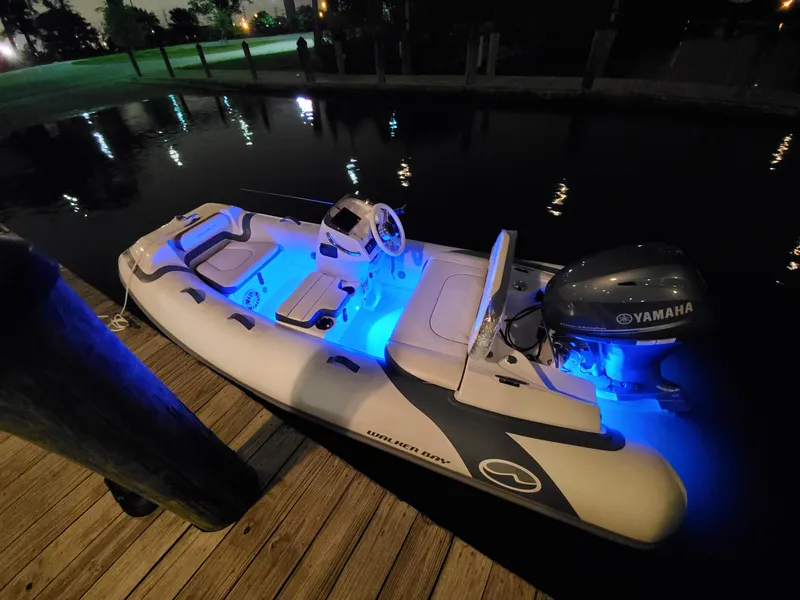 Slide: The Image of Walker Bay Generation 11 LTE 2025 boat with blue LED lights docked at night. - 5