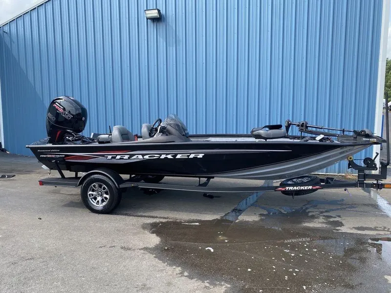 The Image of 2023 Tracker Pro Team™ 195 TXW fishing boat parked outside a blue building. - 1
