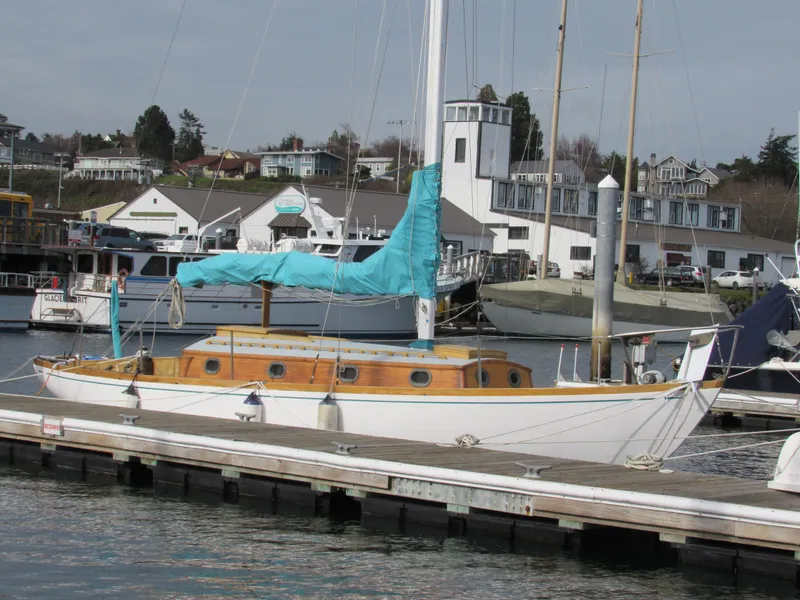 Slide: The Image of 1957 Sparkman & Stephens K35 sailboat docked at a marina with blue cover. - 11