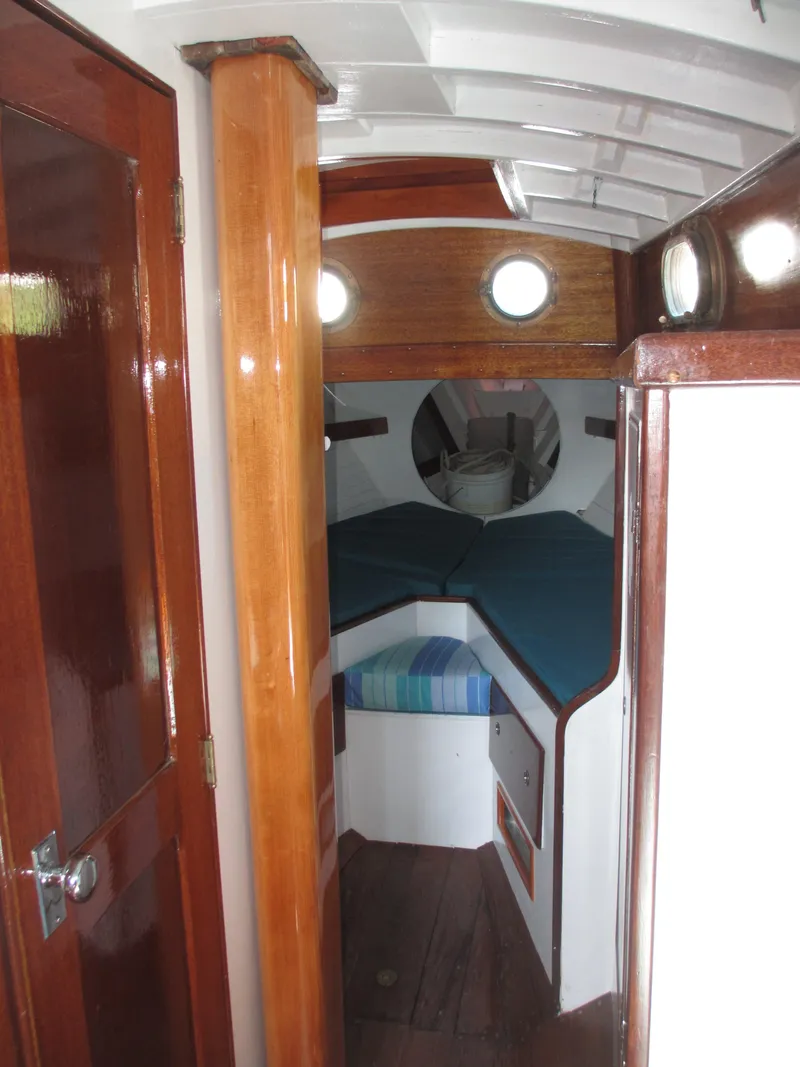 Slide: The Image of 1957 Sparkman & Stephens K35 yacht interior with wooden finishes and cozy sleeping area. - 13