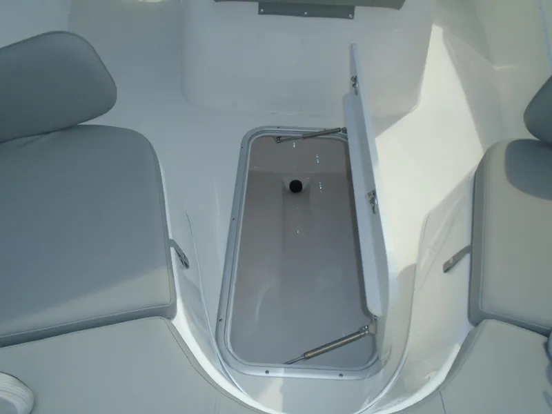 Slide: The Image of 2024 Cape Horn 27XS boat interior storage compartment with open hatch and seating. - 11