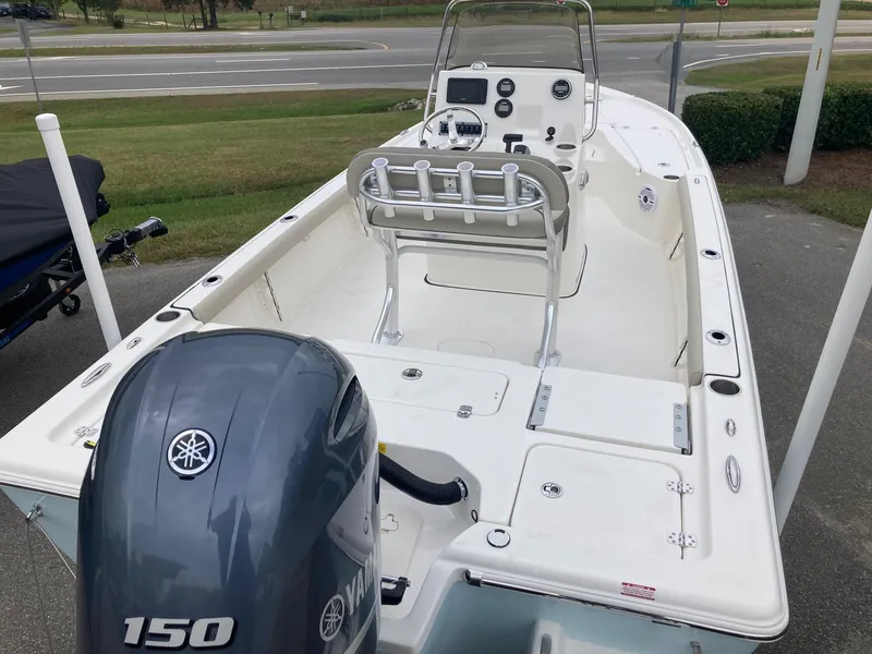 Slide: The Image of 2024 Key West 210 Bay Reef boat with Yamaha 150 engine, docked on pavement. - 2