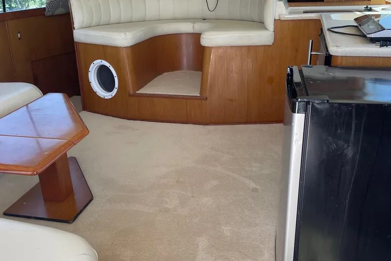 Slide: The Image of Interior of a 1998 Ocean Yachts 40 Sport Fish with seating, table, and mini fridge. - 11