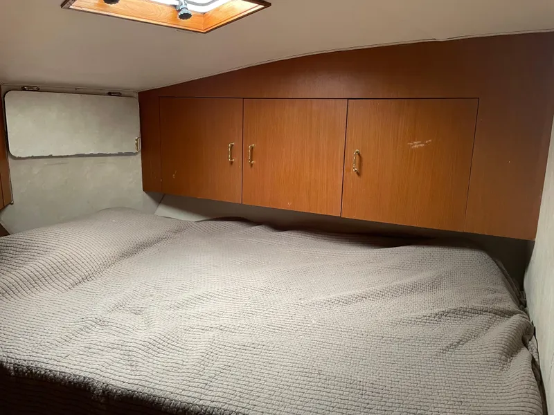 Slide: The Image of 1998 Ocean Yachts 40 Sport Fish cabin with bed and wooden storage cabinets. - 13