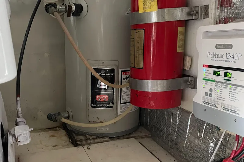 Slide: The Image of 1998 Ocean Yachts 40 Sport Fish engine room with water heater and fire extinguisher. - 21