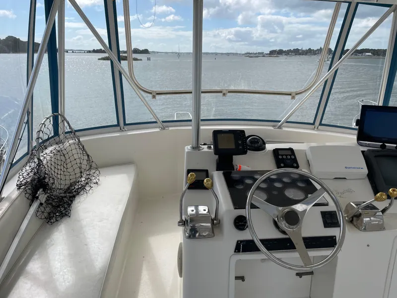 Slide: The Image of 1998 Ocean Yachts 40 Sport Fish helm with steering wheel, controls, and scenic water view. - 8