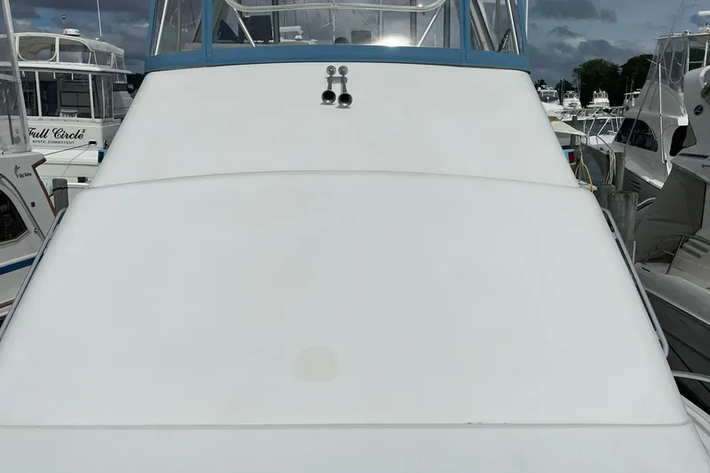Slide: The Image of 1998 Ocean Yachts 40 Sport Fish boat docked at a marina, viewed from the front. - 7