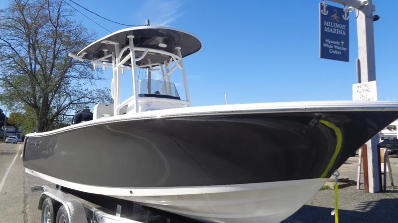 Slide: The Image of 2020 Sportsman 231 Heritage boat on trailer at a marina under clear blue sky. - 4