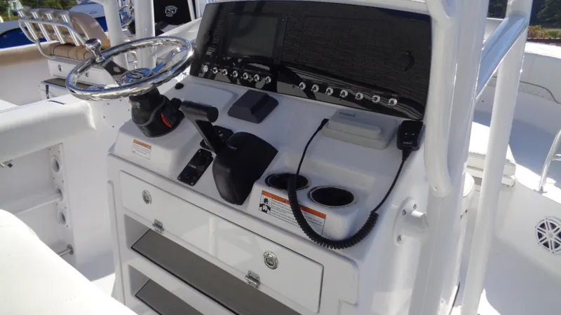 Slide: The Image of 2020 Sportsman 231 Heritage boat console with steering wheel, controls, and storage compartments. - 5