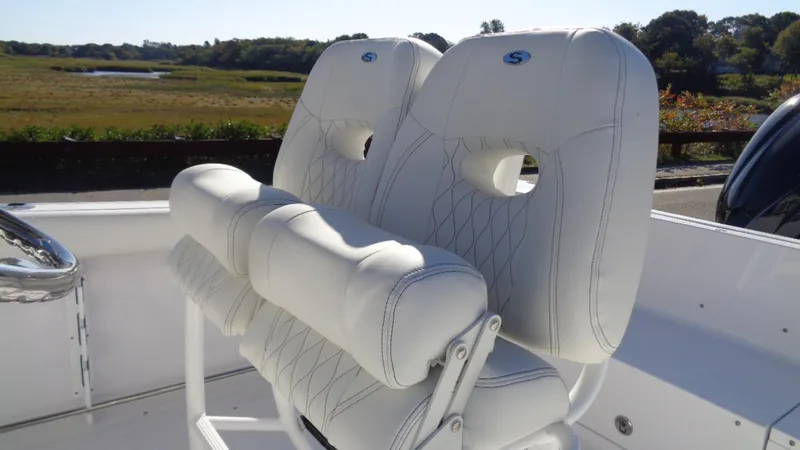 Slide: The Image of White leather seats on a 2020 Sportsman 231 Heritage boat, with scenic background. - 6