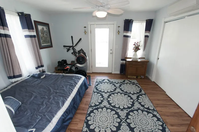 Slide: The Image of Interior of 2017 Chesapeake 48 Houseboat bedroom with exercise equipment and decorative rug. - 10