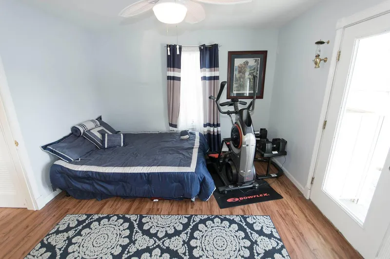 Slide: The Image of Bedroom in 2017 Chesapeake 48 Houseboat with bed, exercise bike, and decorative rug. - 11