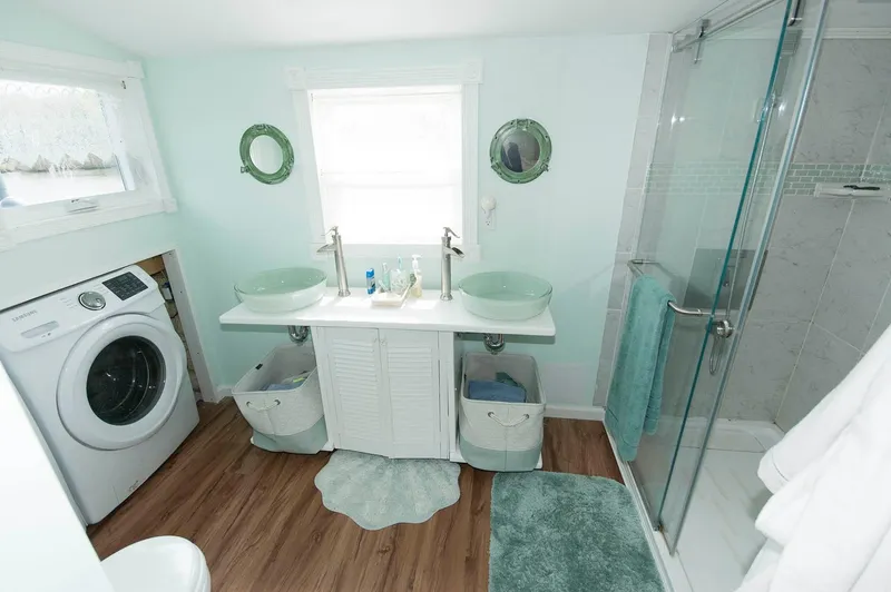 Slide: The Image of Modern bathroom in 2017 Chesapeake 48 Houseboat with dual sinks, washer, and glass shower. - 17