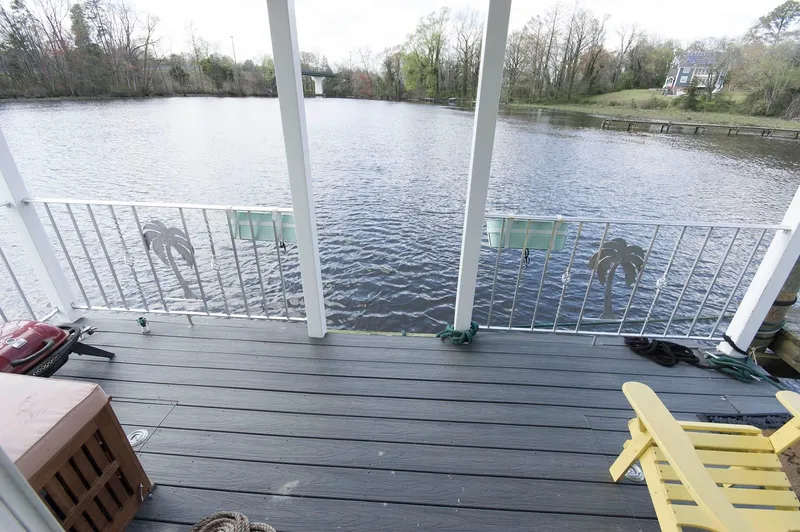 Slide: The Image of Deck view from 2017 Chesapeake 48 Houseboat overlooking serene lake and lush trees. - 2