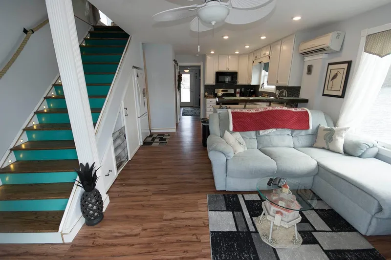 Slide: The Image of 2017 Chesapeake 48 Houseboat interior with modern kitchen, teal stairs, and cozy living area. - 3