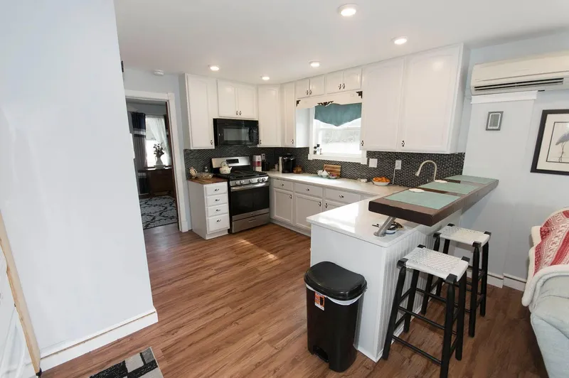 Slide: The Image of Modern kitchen in 2017 Chesapeake 48 Houseboat with white cabinets and wood flooring. - 5