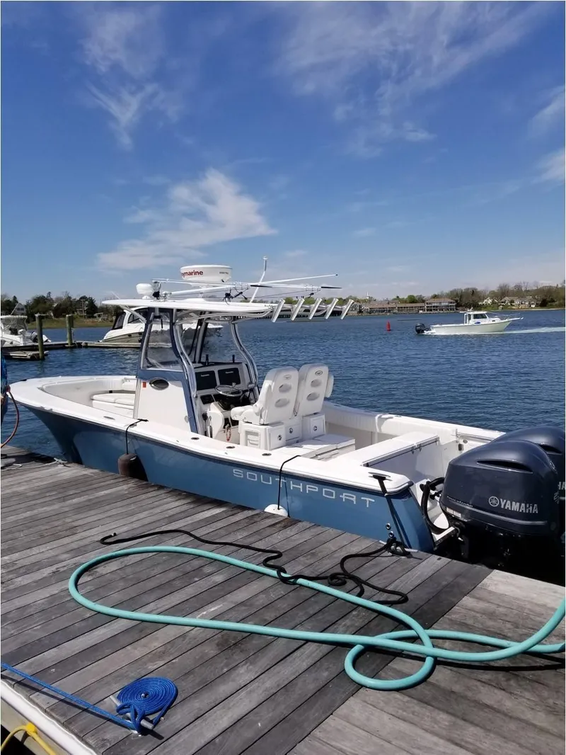 Slide: The Image of 2013 Southport 27 Center Console boat docked by the water, featuring Yamaha engine. - 10