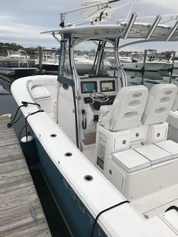 Slide: The Image of 2013 Southport 27 Center Console boat docked, featuring dual seats and advanced navigation equipment. - 12