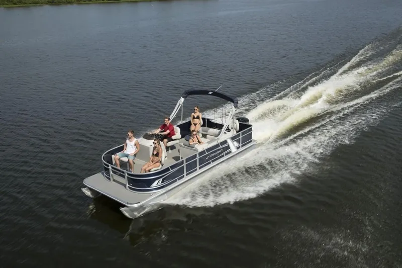 Slide: The Image of 2024 Starcraft 22 LX pontoon boat cruising on a lake with passengers. - 5
