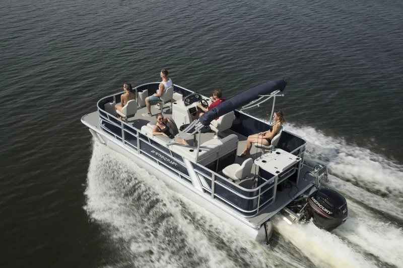 Slide: The Image of 2024 Starcraft 22 LX pontoon boat cruising on water with passengers. - 7