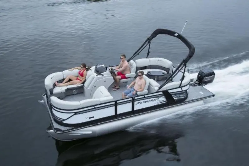 Slide: The Image of 2024 Starcraft SLS 1 pontoon boat cruising with passengers on a lake. - 9