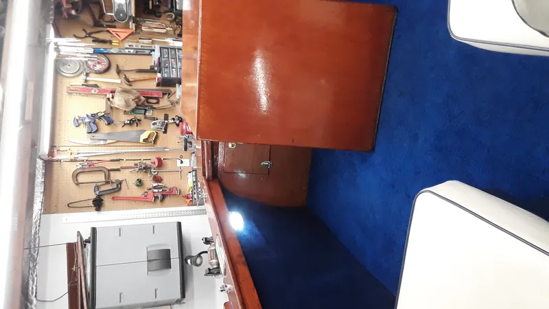 Slide: The Image of Workshop with tools and a 1965 Thompson Sea Lancer interior featuring blue carpet and wooden paneling. - 11