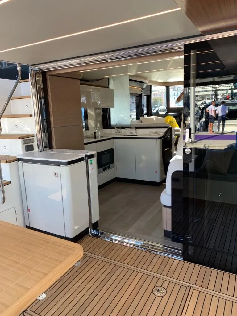 Slide: The Image of 2024 Absolute 58 Navetta yacht interior with modern kitchen and wooden flooring. - 16
